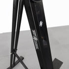 Black metal stand with visible branding on a gray surface