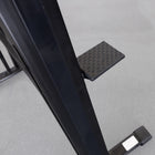 Black metal frame with a textured footrest on a gray floor