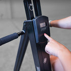Person using a digital display on a climber machine with a blurred background