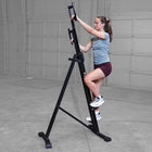 Woman using Best Fitness BFMC10B Mountain Climber in a garage setting