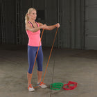 Woman exercising with resistance bands in a garage setting