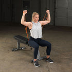 Woman exercising with resistance bands in a home gym setting