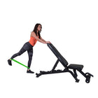 Woman using a weight bench with a green resistance band on a white background