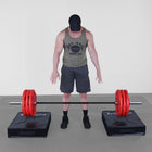 Person standing between two weightlifting platforms with a barbell on a plain background