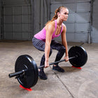 Woman lifting a barbell in a garage setting