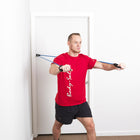 Man in a red shirt using resistance bands against a white door.
