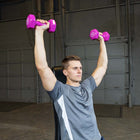 Man exercising with pink dumbbells in a garage setting