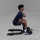 Person using a Body Solid GSS50B Sissy Squat in a gray room
