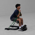 Person using Body Solid GSS50B Sissy Squat on a gray floor.