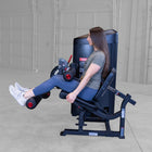 Woman using a leg press machine in a gym setting