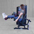 Person using a leg press machine in a gym setting