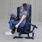 Woman using a leg press machine in a gym setting