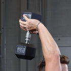 Person lifting a 40-pound dumbbell with a blurred background