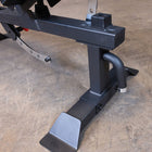 Black weight bench with footrest on a concrete floor