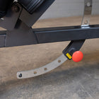 Close-up of a metal lever with a red knob on a concrete surface