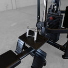 Close-up of a gym machine with a black seat and metal components on a concrete floor.