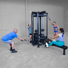 Group of people exercising using a cable machine in a gym setting.