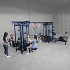 Group of people exercising in a gym with weightlifting equipment.