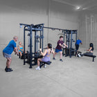 Group of people exercising on fitness equipment in a gym.
