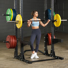 Woman performing squats with a barbell in a gym setting