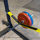 Weightlifting barbell with red and blue weight plates on a weight rack.