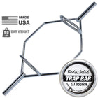 A chrome hexagonal trap bar with a circular Body-Solid OTB50RH weight plate shown alongside it on a white background, with 'MADE USA' and 'BAR WEIGHT 50 LBS' text graphics in the upper left.